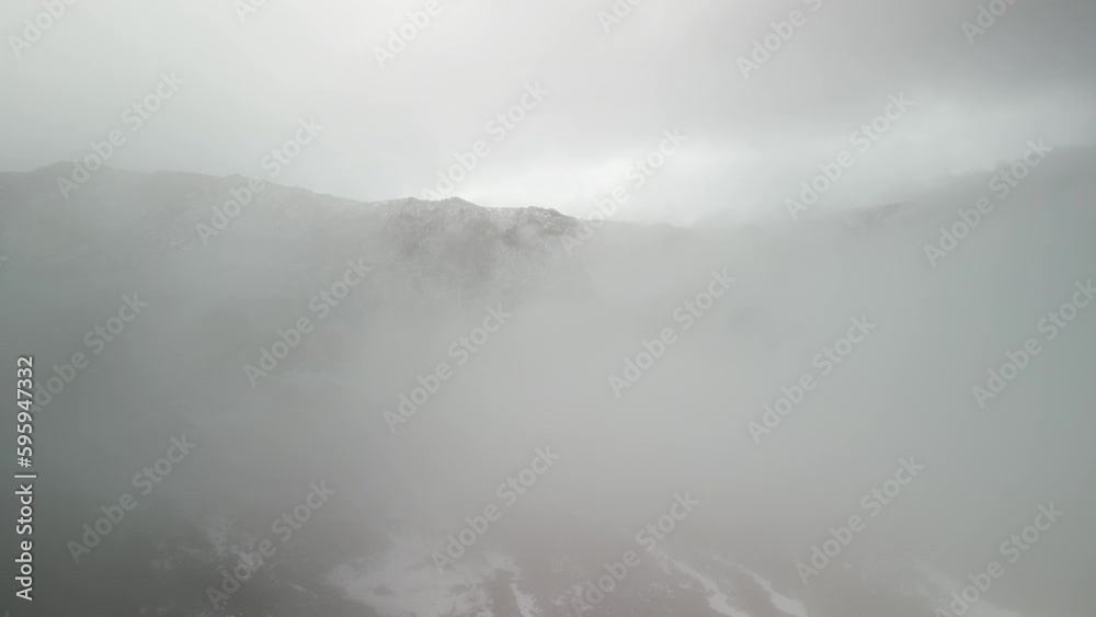 Aerial fly through low clouds to reveal rocky mountains covered in snow in Colorado near Gunnison Aerial fly through low clouds to reveal rocky mountains covered in snow in Colorado near Gunnison