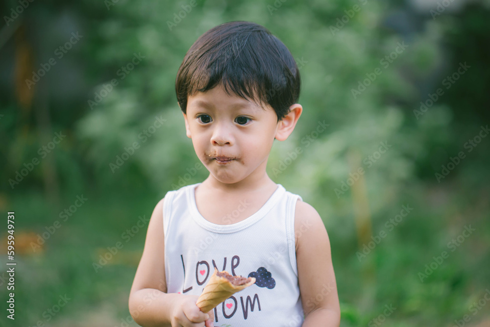Asia boy he mouth aftertaste from eating chocolate ice cream or chocolate dessert. A sweet-toothed child eat chocolate. Asia boy he mouth aftertaste from eating chocolate ice cream or chocolate dessert. A sweet-toothed child eat chocolate.