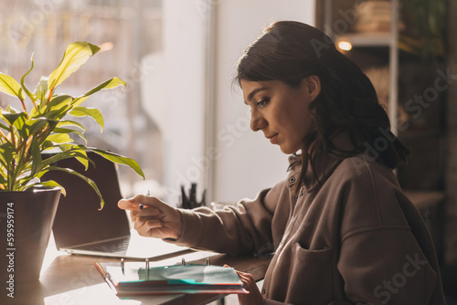 An attractive young woman works online in a cafe.Remote work, business, freelance,online education.