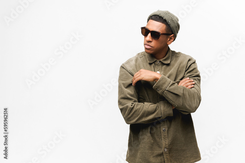 Handsome young african-american hipster man isolated on white, guy in sunglasses and hat looking away with serious face expression, fashion man posing