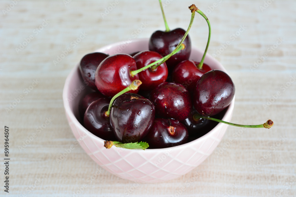 A heap of cherries in pink bowl isolated, macro A heap of cherries in pink bowl isolated, macro