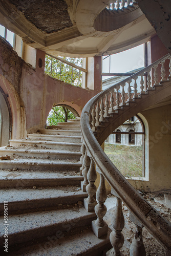 Old abandoned mansion with decorated spiral staircase
