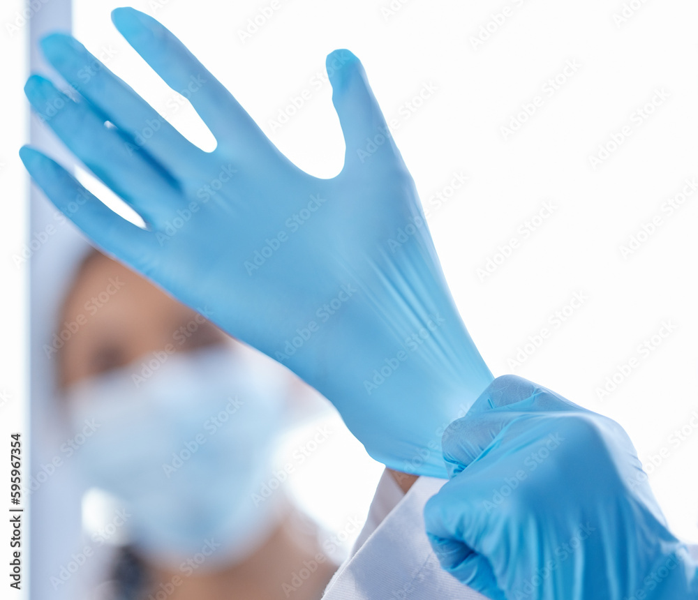 Lets get started. Closeup shot of an unrecognizable doctor putting on gloves while treating covid patients in the hospital. Lets get started. Closeup shot of an unrecognizable doctor putting on gloves while treating covid patients in the hospital.