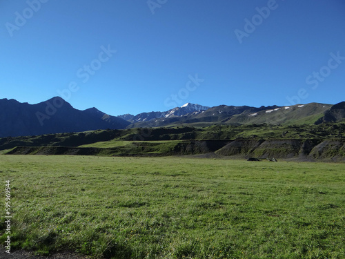 green valley at the foot of the mountains. pasture for cows and sheep.