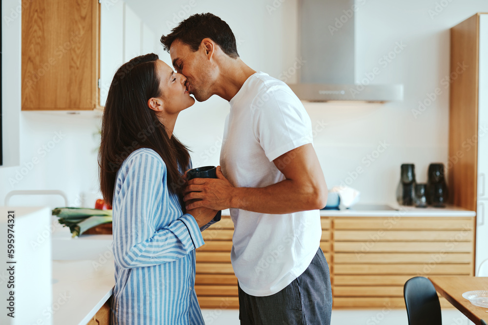 Couple kissing over coffee at home Couple kissing over coffee at home