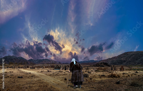 An elderly woman walking to the grave.