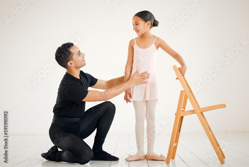 Ballet has instilled so much confidence in her. a ballet teacher assisting a student with her position in a dance studio.