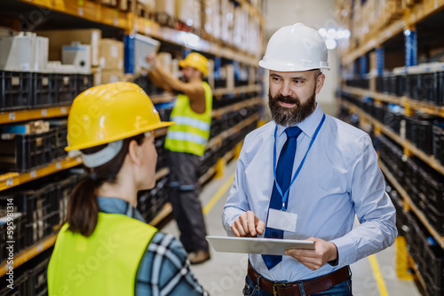 Manager explaining work to his employers in warehouse.