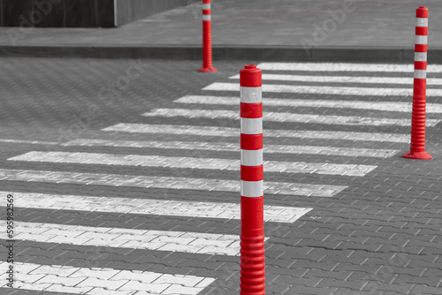 Empty pedestrian crossing and rubber signal posts. Red rubber column. Empty zebra. Lines on the road. Safety on the road. Signs for pedestrians. Rubber signal posts. Road markings. photo