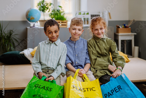 Children separating rubish in to three bins. photo