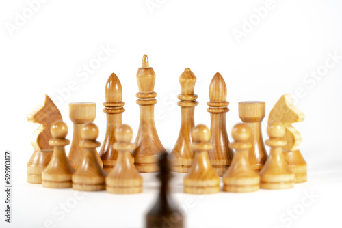 Chess pieces on a white background. Black pawn against all white pieces