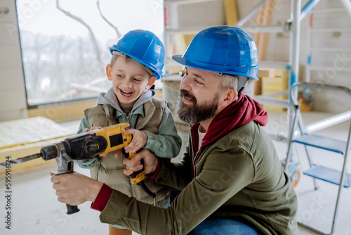 Father and his little son working on their unfinished house.