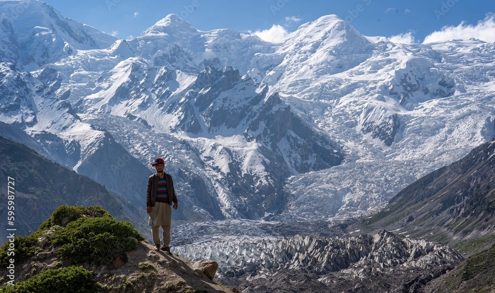 Garçon devant un glacier et de hautes montagnes enneigées