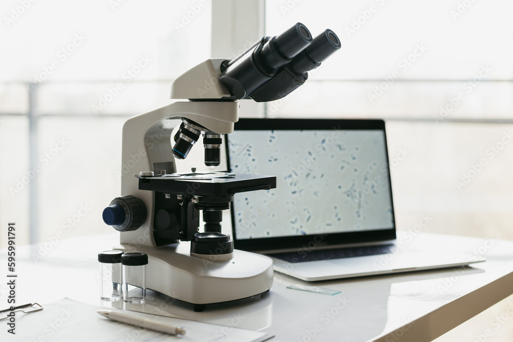 Medical laboratory, microscope and laptop computer on scientist office desk, Scientific and healthcare concept Medical laboratory, microscope and laptop computer on scientist office desk, Scientific and healthcare concept