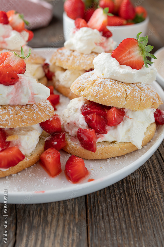 Summer strawberry cake or pastry with traditional shortcakes filled with whipped cream and marinated strawberries Summer strawberry cake or pastry with traditional shortcakes filled with whipped cream and marinated strawberries