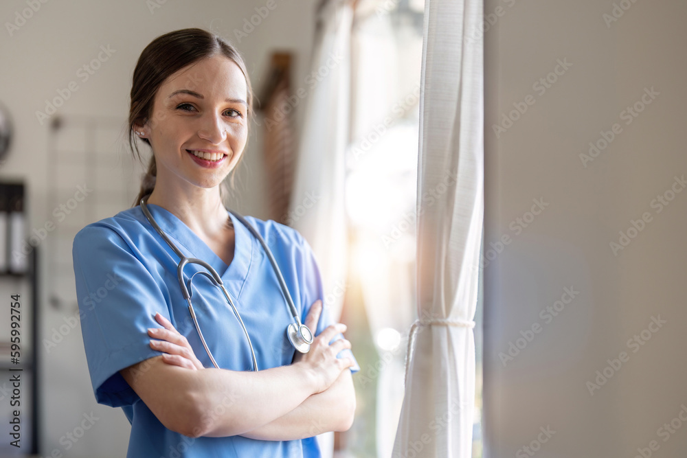 Smiling female doctor with stethoscope around neck standing with arms crossed. She is dedicated and experienced doctor Smiling female doctor with stethoscope around neck standing with arms crossed. She is dedicated and experienced doctor
