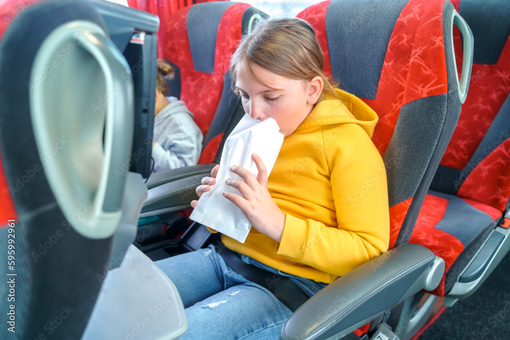 Girl is sick, vomits in bag. Bus road traveling. Girl kid feels bad