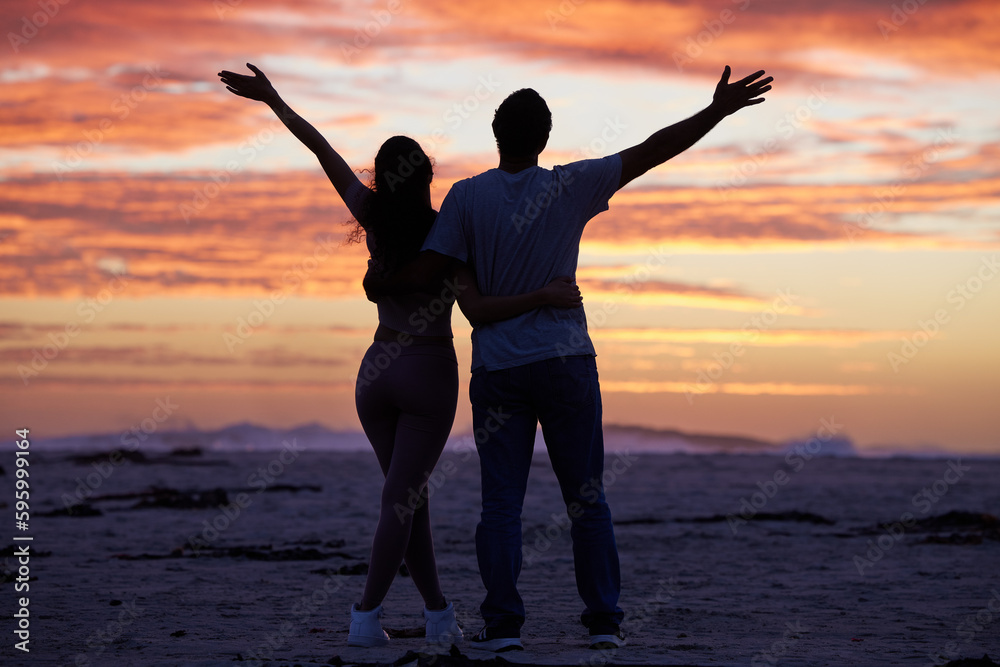 I know where I get my free spirit from. Full length shot of an unrecognisable woman standing with her father on the beach with her arms raised.