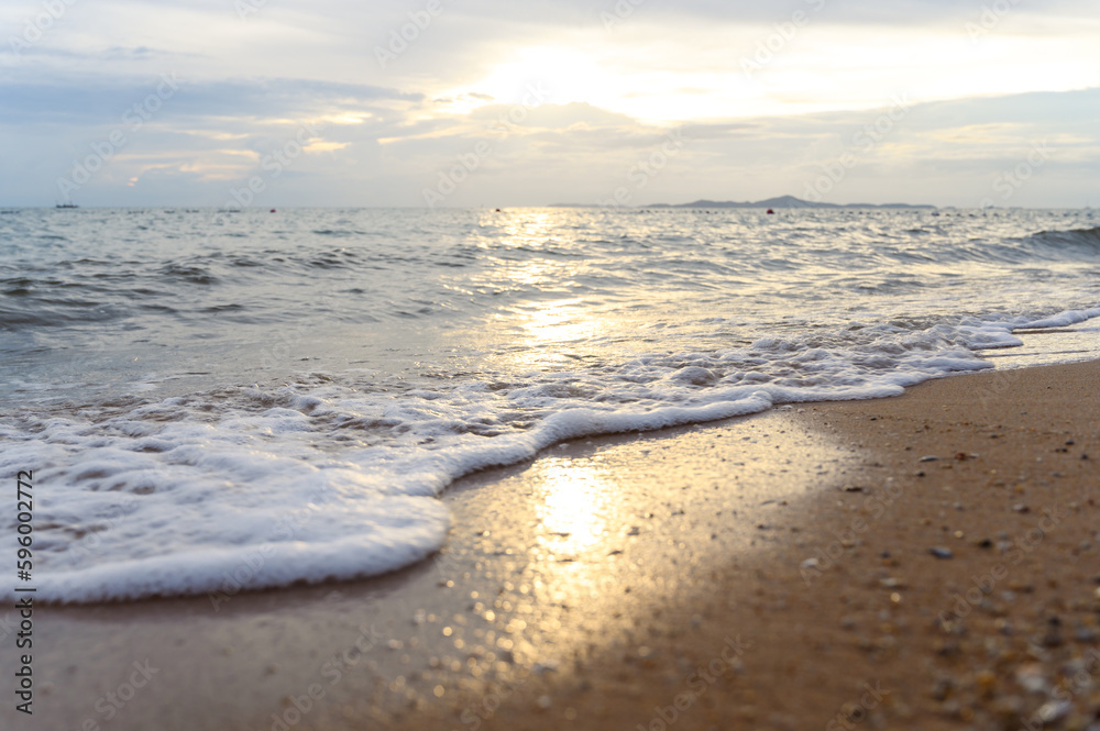 Seawater soft wave crashing on sandy beach seaside in summer on sunset time. summer vacation activity background concept.. Seawater soft wave crashing on sandy beach seaside in summer on sunset time. summer vacation activity background concept..