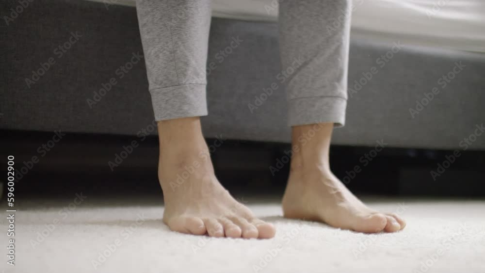Feet of a young man getting out of bed with energy and stretching his toes