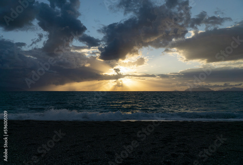 Beautiful and relaxing sunset at milazzo beach with cloudy blue sky and mediterranean sea 