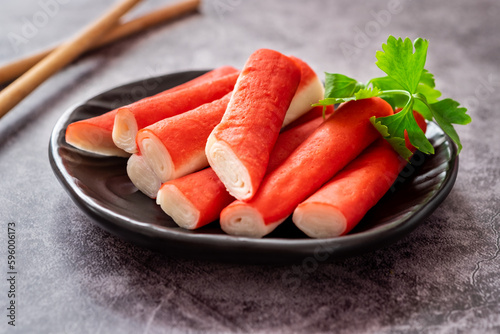 Fresh crab sticks on black plate