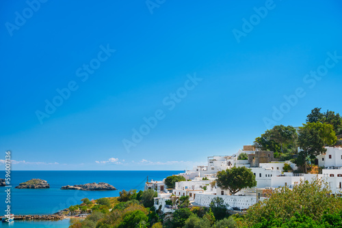 View of the bay and snow-white houses of the ancient city of Lindos on the Greek island of Rhodes, view of the Aegean Sea, the islands of the Dodecanese archipelago, Europe