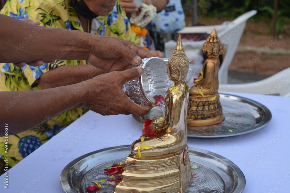 Old hands of people bathing Buddha images