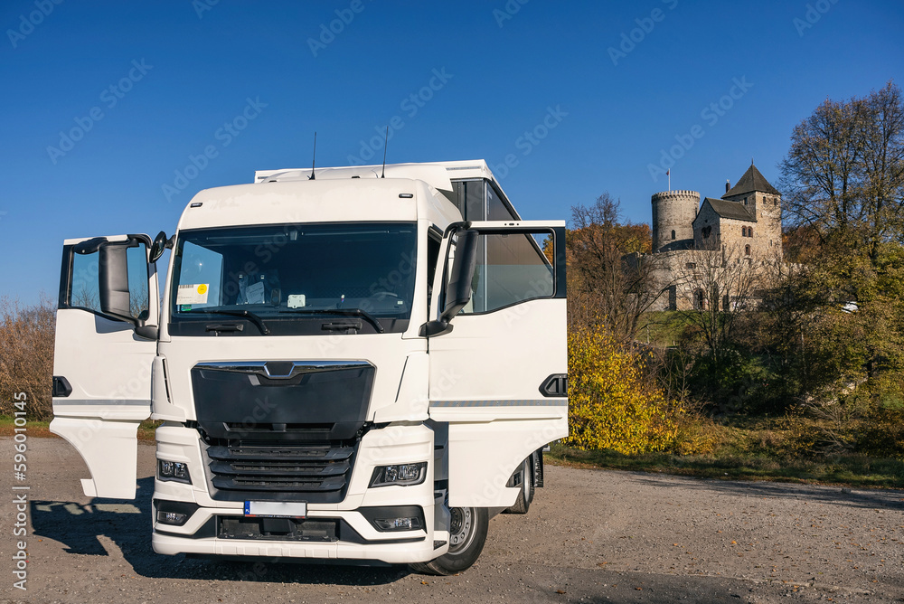Truck on the background of the castle. Car transport . Truck with semi-trailer in gray color.  Truck photo for calendar