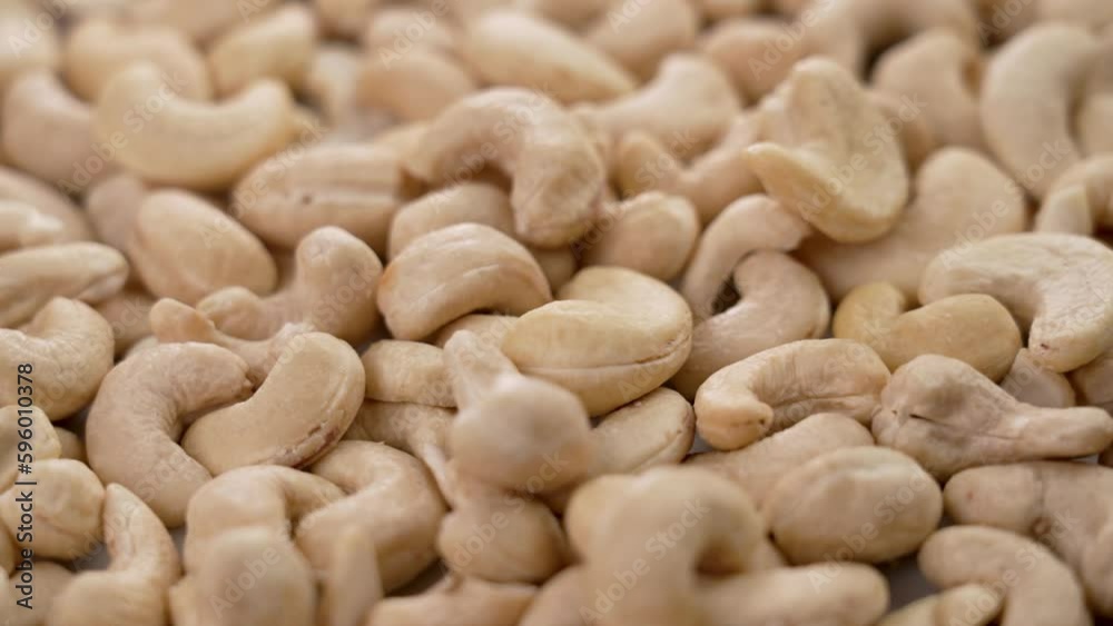 Raw cashew nuts falling in slow motion closeup. Natural healthy dietary ingredient. Rotation Raw cashew nuts falling in slow motion closeup. Natural healthy dietary ingredient. Rotation