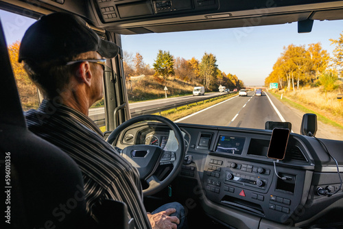 View from inside the cab of the truck. The truck is driving down the road. Car transport. photo