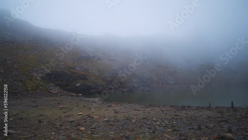 4K shot of holy Brigu Lake in Manali high on the mountains of Himalayas. Handhalded shot of Bhrigu lake covered with fog in summer season. photo