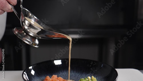 Drops of sauce pouring in slow motion. Black background. sauce or liquid drops pouring from decanter, adding to dish, food video in restaurant. Chef plating up food in restaurant pouring gravy or