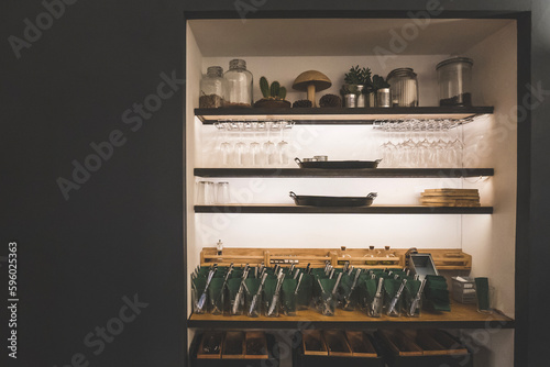 Set of utensils, glass wines and containers arranged on a wall wooden shelves in cafe or restaurant