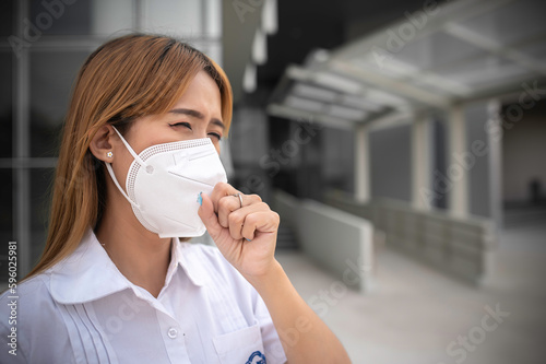 Asian woman wear N95 mask for protect dust pm 2.5,ecology concept. Allergy, headache. air danger in city.