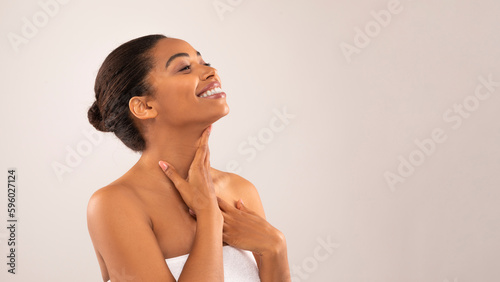 Hot cheerful young black woman massaging her neck, copy space