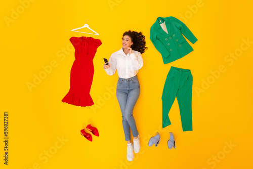 Woman Shopping Online In Application Using Cellphone Lying, Yellow Background