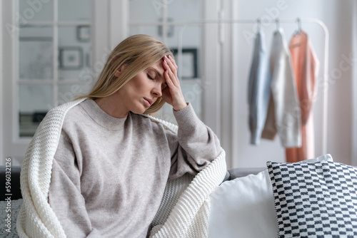 worried blonde woman with headache and fever