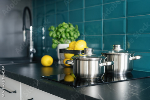 cookware at kitchen with glass ceramic stove and modern interior photo