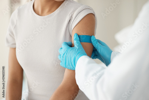 Keep this on for the day. an unrecognisable doctor applying a band-aid after injecting her patient during a consultation in the clinic.