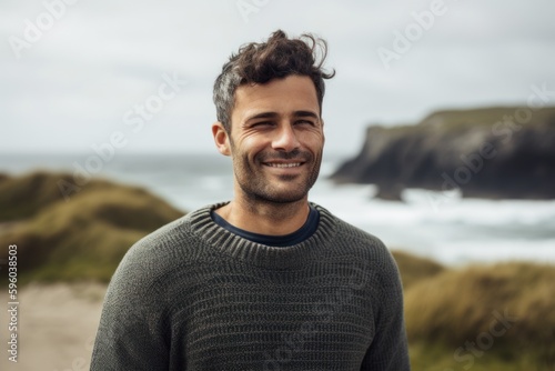 Portrait of handsome man smiling at camera on the beach in Iceland