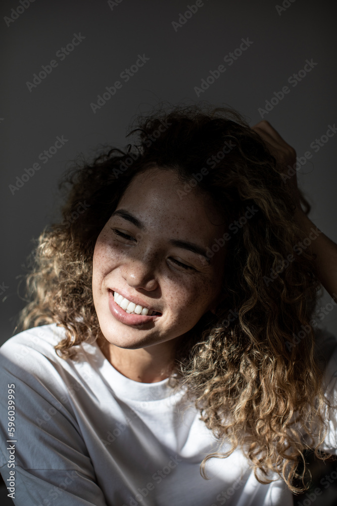Smiling woman with curly hair and freckles on her face. Smiling woman with curly hair and freckles on her face.