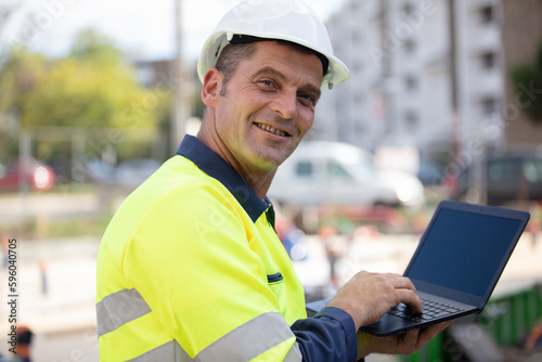 happy architect holding laptop outdoor