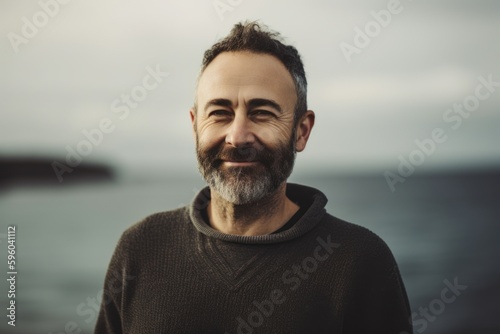 Portrait of a handsome bearded man with a gray beard on the background of the sea