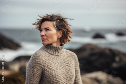 Portrait of a middle aged woman in a sweater on the beach © Robert MEYNER