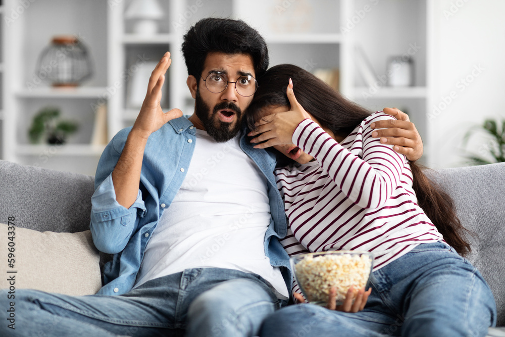 Frightened indian couple watching horror at home Frightened indian couple watching horror at home