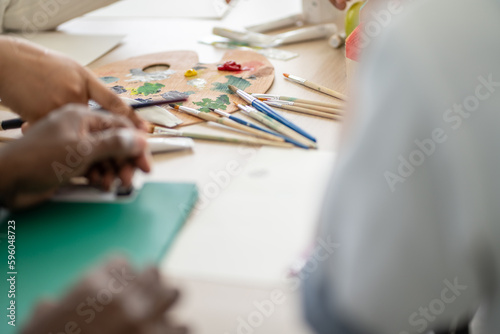 Background of drawing and painting tools on the table. color palette plate and paint brush. Arts class or home room activity at school