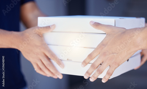 Delivered to you, hot and fresh. Closeup shot of an unrecognisable man delivering pizzas to a customer. photo