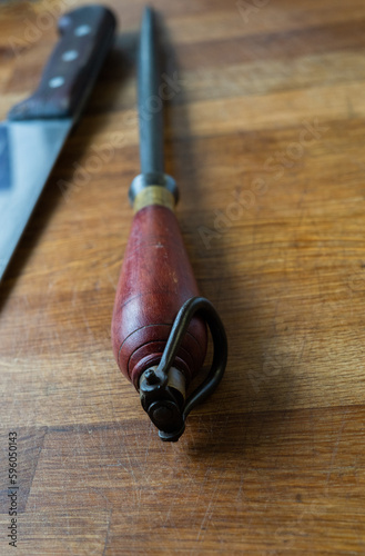 A retro butcher knife and steel on a wooden table