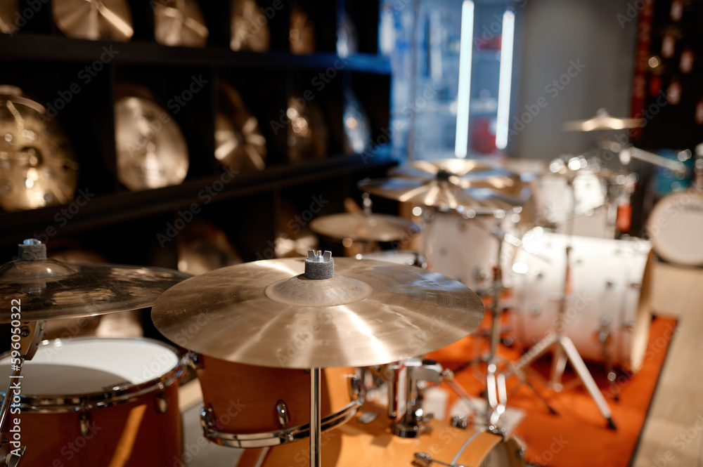 Selective view on drum set and several golden cymbal plates in music shop Selective view on drum set and several golden cymbal plates in music shop